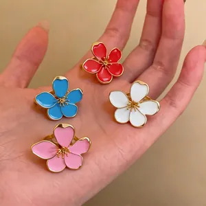 Elegant enamel flower open rings in four vibrant colors displayed beautifully on a palm