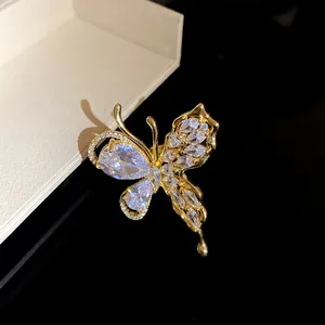 Primo piano di un anello aperto a farfalla con zirconi e finitura dorata.