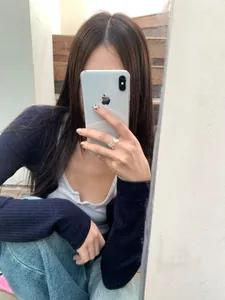 Nahaufnahme eines silbernen offenen Rings mit Seestern und Muschel am Finger beim Selfie