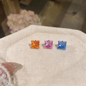 Set minimalista di tre orecchini a lobo in zircone a forma di stella su tela beige