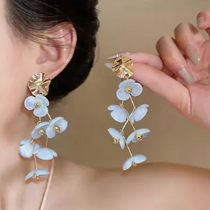 Elegant long dangling flower earrings with gold metal and light blue acrylic petals