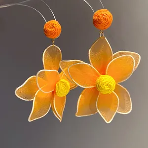 Detailed close-up of vibrant orange and yellow floral mesh petal earrings
