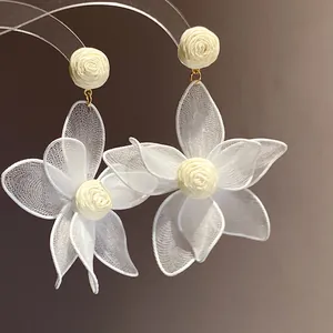 Detailed close-up of elegant white mesh flower drop earrings with rose-shaped stud