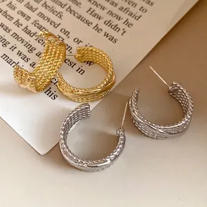 Vintage C-shaped hoop earrings with textured woven pattern in gold and silver finish.