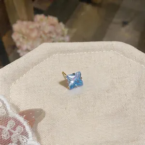 Dettaglio ravvicinato dell'orecchino a lobo con zircone blu sfaccettato e perno dorato