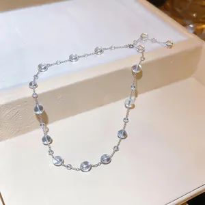 Dettaglio di una collana delicata con perline in vetro trasparente e catena argento