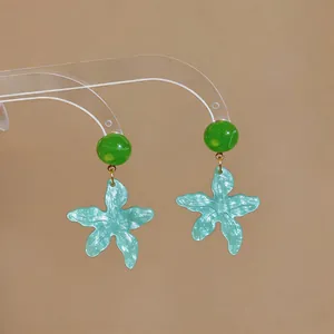 Dettaglio orecchini pendenti a stella marina verde menta con perline verde smeraldo.