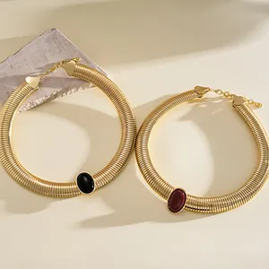 Detailed view of vintage gold-toned ribbed necklaces with black and red oval resin stones