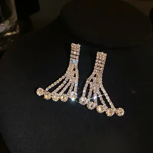 Close-up of elegant rhinestone fringed earrings with sparkling circular pendants