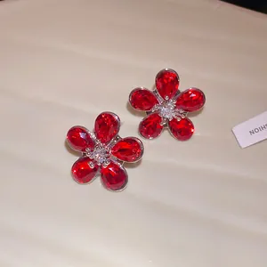 Detailed macro view of elegant red crystal flower stud earrings with high-quality silver needles