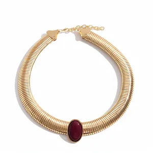 Chunky gold-tone ribbed metal collar necklace with dark burgundy resin oval centerpiece