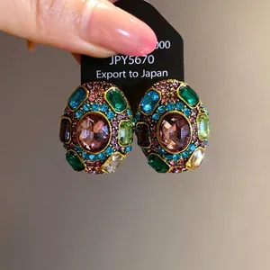 Vintage style gold-toned stud earrings decorated with multi-colored crystals and stones