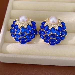 Boucles d'oreilles vintage dorées avec perles bleues et détail de perle blanche