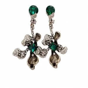 Vintage emerald flower drop earrings with rhinestones on white background