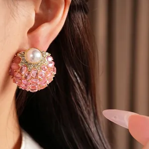 Boucles d'oreilles perles vintage avec grappes de gemmes roses sur l'oreille du modèle