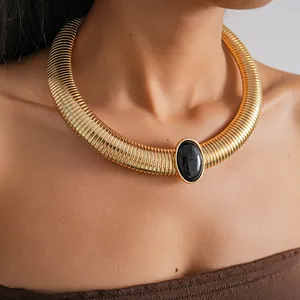Detailed view of vintage chunky gold metal necklace with central black resin oval stone