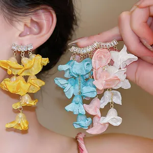 Close-up detail of elegant zircon and colorful chiffon petal flower tassel earrings.
