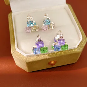 Detailed macro shot of colorful geometric square glass earrings in velvet jewelry box
