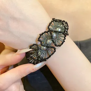 Elegant handmade beaded floral bracelet with grey pearls on wrist