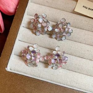 Detailed view of elegant flower-shaped stud earrings with pastel enamel finish