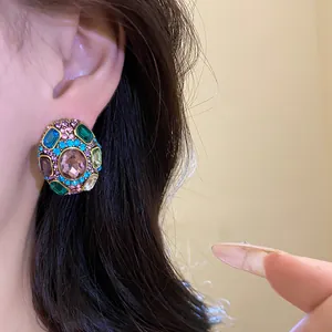 Detailed macro view of vintage multi-colored crystal stud earring worn on a model's ear