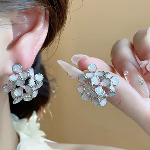 Detailed macro shot of sweet floral earrings with blue oil drip finish on silver needle
