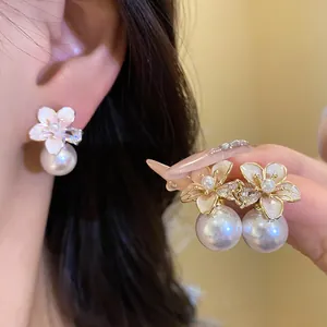 Primo piano dettagliato di eleganti orecchini a fiore placcati oro 18k con perle