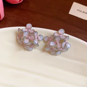Close-up of sweet floral stud earrings featuring sparkly pink enamel and silver edges