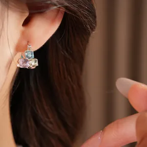 Detailed close-up of minimalist geometric square earrings with vibrant colored glass stones