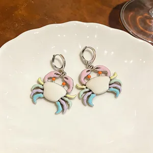 Close-up of cute pastel enamel crab earrings with colorful legs and silver hoop.