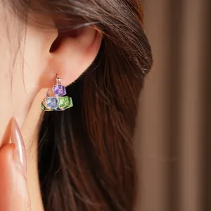 Close-up of colorful geometric glass square earrings with a minimalist design