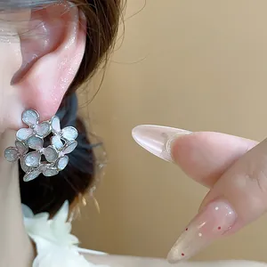 Close-up of elegant floral stud earrings with iridescent oil drip enamel petals