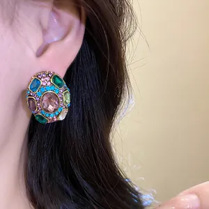 Close-up detail of vintage style oval earrings with colorful multi-gemstone embellishments