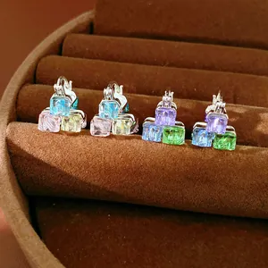 Close-up of colorful geometric glass cube earrings in a brown velvet jewelry box