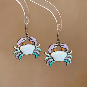 Close-up of cute enamel crab drop earrings with vibrant cartoon design and colors
