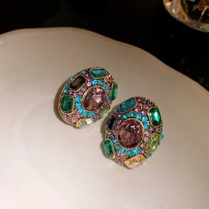 Vintage multi-colored gemstone encrusted stud earrings in an ornate golden setting
