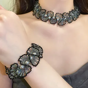 Detail view of the intricate beaded floral necklace and matching bracelet on a model.
