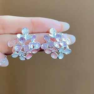 Close-up detail of silver needle enamel flower stud earrings in pink and purple