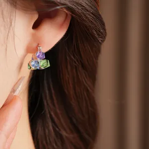 Detailed view of colorful geometric glass cube charms on silver hoop earring