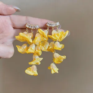 Detailed view of yellow chiffon tassel earrings with sparkling cubic zirconia stones.