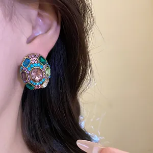 Close-up view of luxury vintage multi-colored rhinestone flower stud earrings on ear