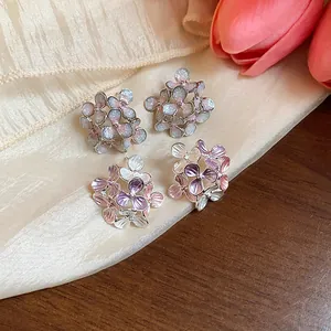 Close-up detail of sweet floral enamel stud earrings with glitter and gradient finish