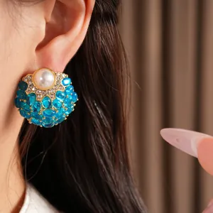 Vue macro détaillée de boucles d'oreilles vintage élégantes avec perle et pierres bleues