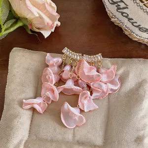Close-up detail of romantic pink chiffon petal earrings with sparkling zircon studs