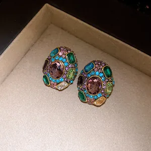 Close-up detail of vintage oval stud earrings encrusted with colorful rhinestones and gems