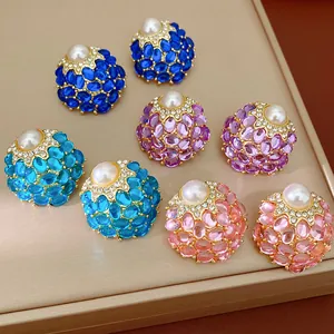 Détail de boucles d'oreilles vintage avec perles et cristaux en couleurs assorties.