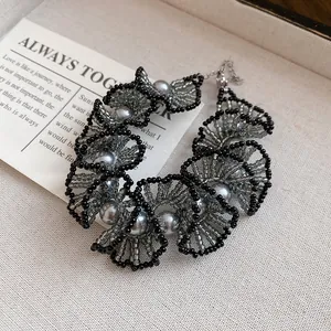 Macro view of elegant grey pearl and black beaded ruffle lace choker necklace