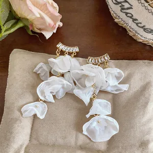 Close-up of white chiffon flower petal tassel earrings with sparkling zircon studs