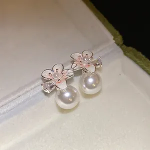 Dettaglio degli orecchini a fiore placcati in oro 18k con perle e smalto rosa delicato