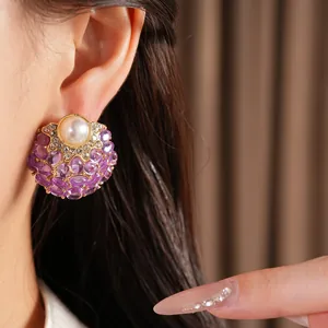 Gros plan sur une boucle d'oreille vintage perle et pierres violettes